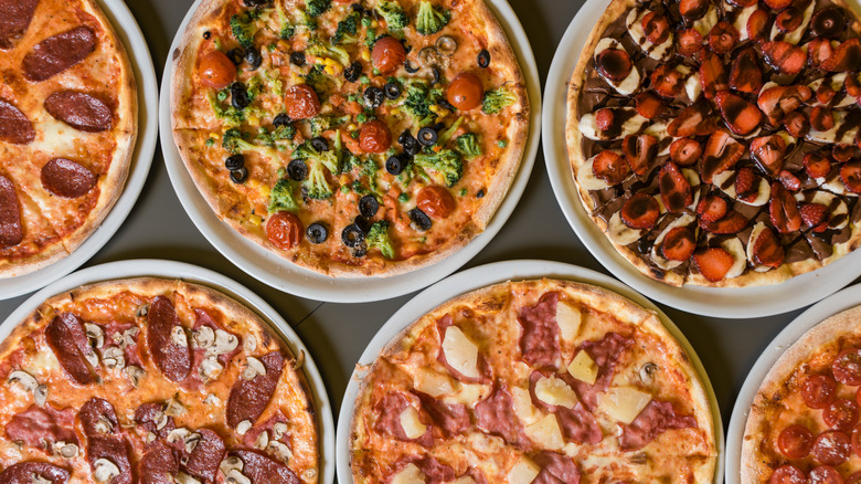 Various types of pizza beside one another on a table