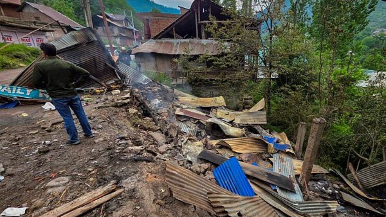 A man stands near damaged houses after shelling by Pakistani troops, in Gingle area of Uri in Baramulla district, Friday. (PTI Photo)