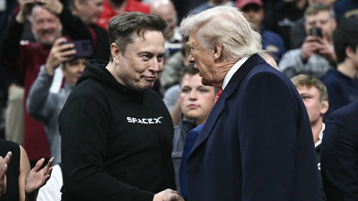 Elon Musk og Donald Trump tar hverandre i hendene og ser på hverandre.