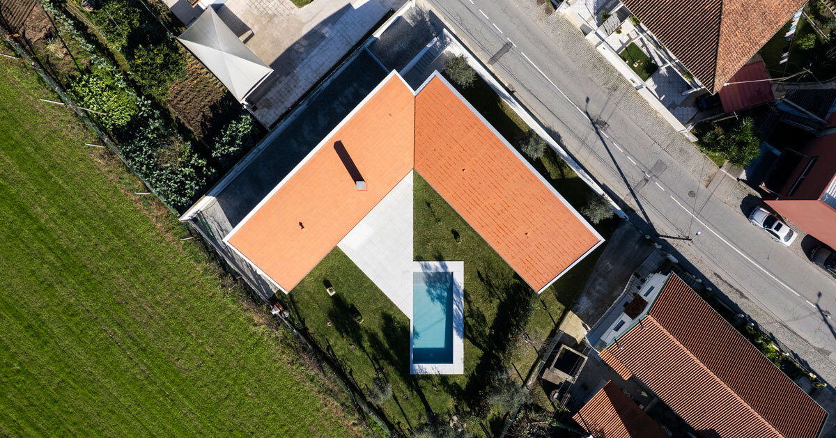 sculptural chimney pierces L-shaped house by martins architecture office in portugal