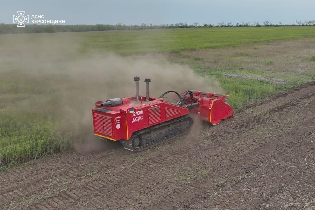 Ukrainian technicians from the State Emergency Service of Ukraine - using a remote-controlled de-mining vehicle as to remove unexploded munitions in fields - in the Kherson Oblast.