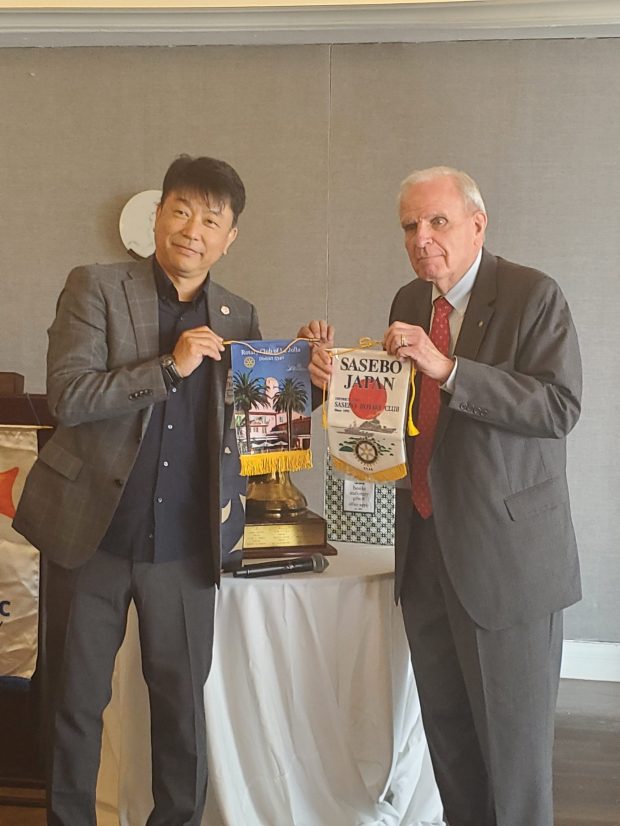 Sasebo Rotary Club President Takahide Serino and Rotary Club of La Jolla President Bob Teaff exchange club flags. (Ashley Mackin-Solomon)