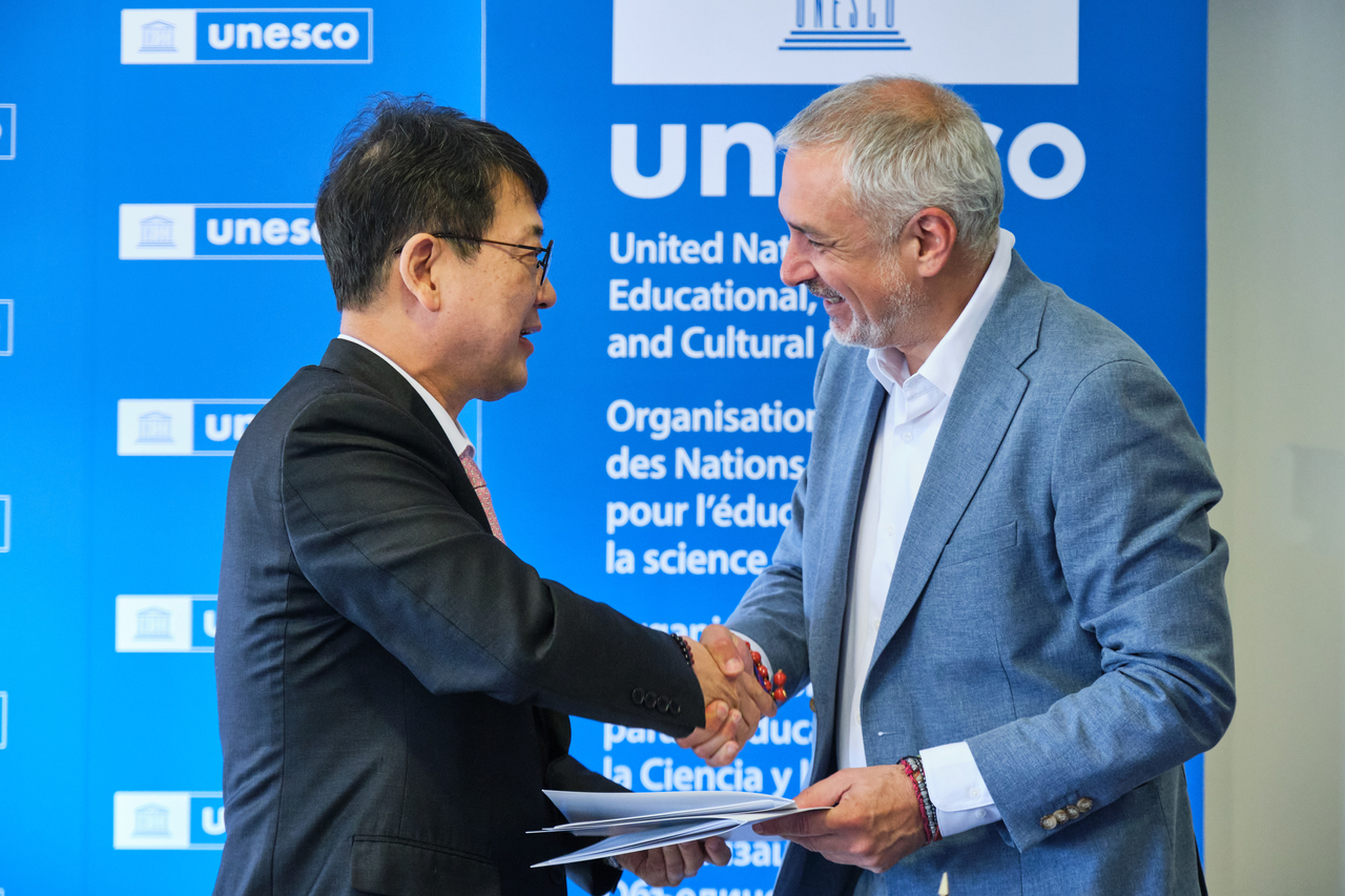 Choi Eung-chon (left), administrator of the Korea Heritage Service and Ernesto Ottone, assistant director-general for culture of UNESCO, shake hands at a signing ceremony in Paris on Friday. (Courtesy of UNESCO)