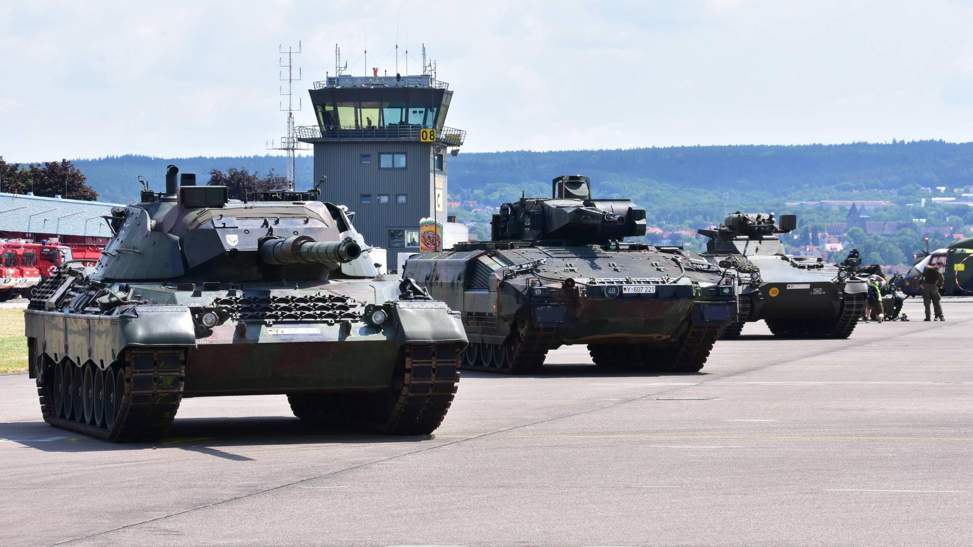 Panzer der Bundeswehr stehen nebeneinander geparkt auf einem Flugplatz. Dahinter sieht man den Tower. Panzer der Bundeswehr stehen nebeneinander geparkt auf einem Flugplatz. Dahinter sieht man den Tower.