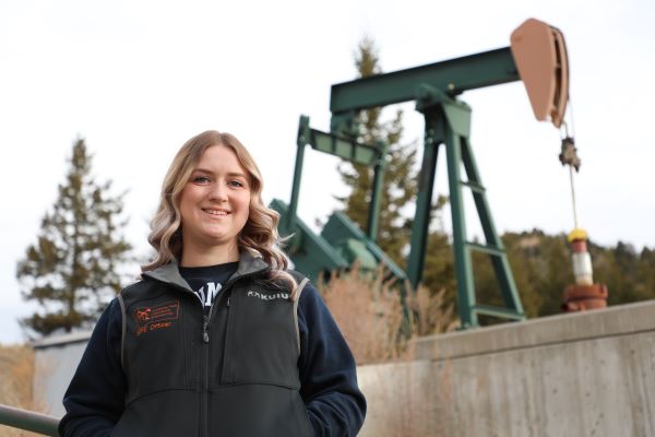 Shaena Jackson poses in front of a pump jack on Montana Tech campus