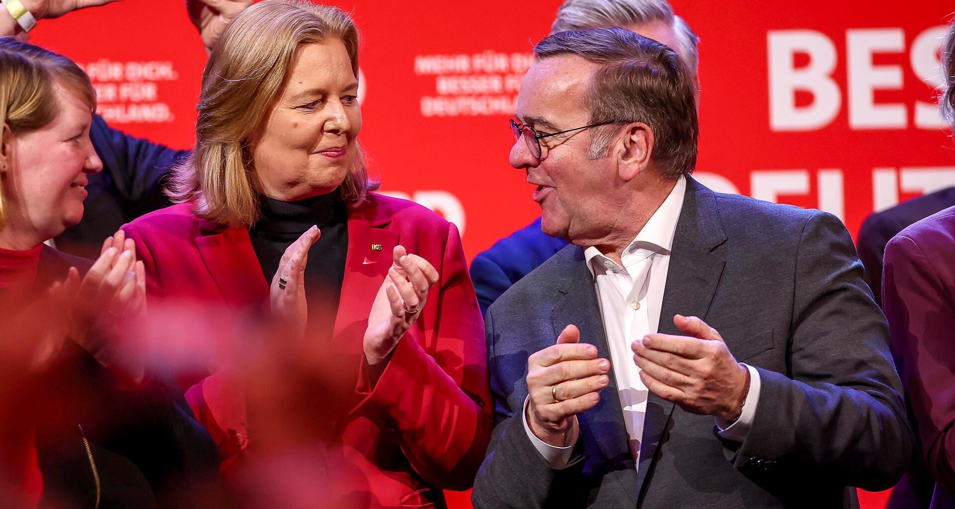 Bärbel Bas steht neben Boris Pistorius auf einer SPD-Wahlveranstaltung in Dortmund. Beide schauen sich an und klatschen in die Hände.