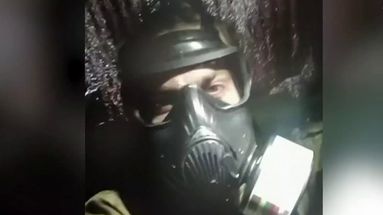 Un membre du bataillon Bratstvo, masque à gaz sur le visage.