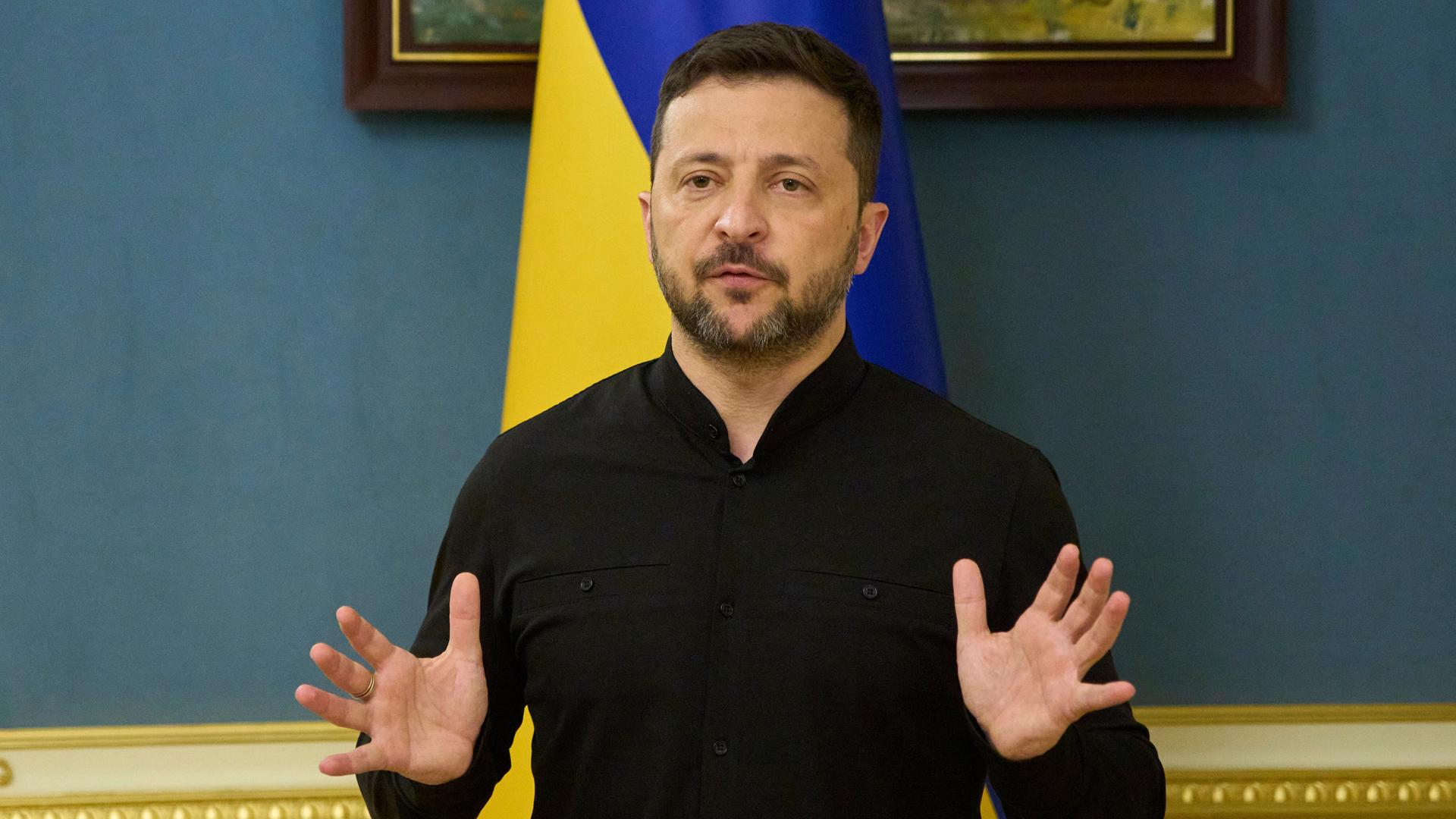 Wolodymyr Selenskyj spricht, während er mt beiden Händen gestikuliert. Im Hintergund ist eine blau-gelbe, ukrainische Flagge zu sehen. Wolodymyr Selenskyj spricht, während er mt beiden Händen gestikuliert. Im Hintergund ist eine blau-gelbe, ukrainische Flagge zu sehen.