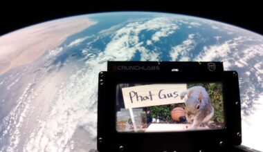 A view of Earth from space with a CrunchLabs frame in the foreground displaying an image of a squirrel next to a sign that says "Phat Gus.