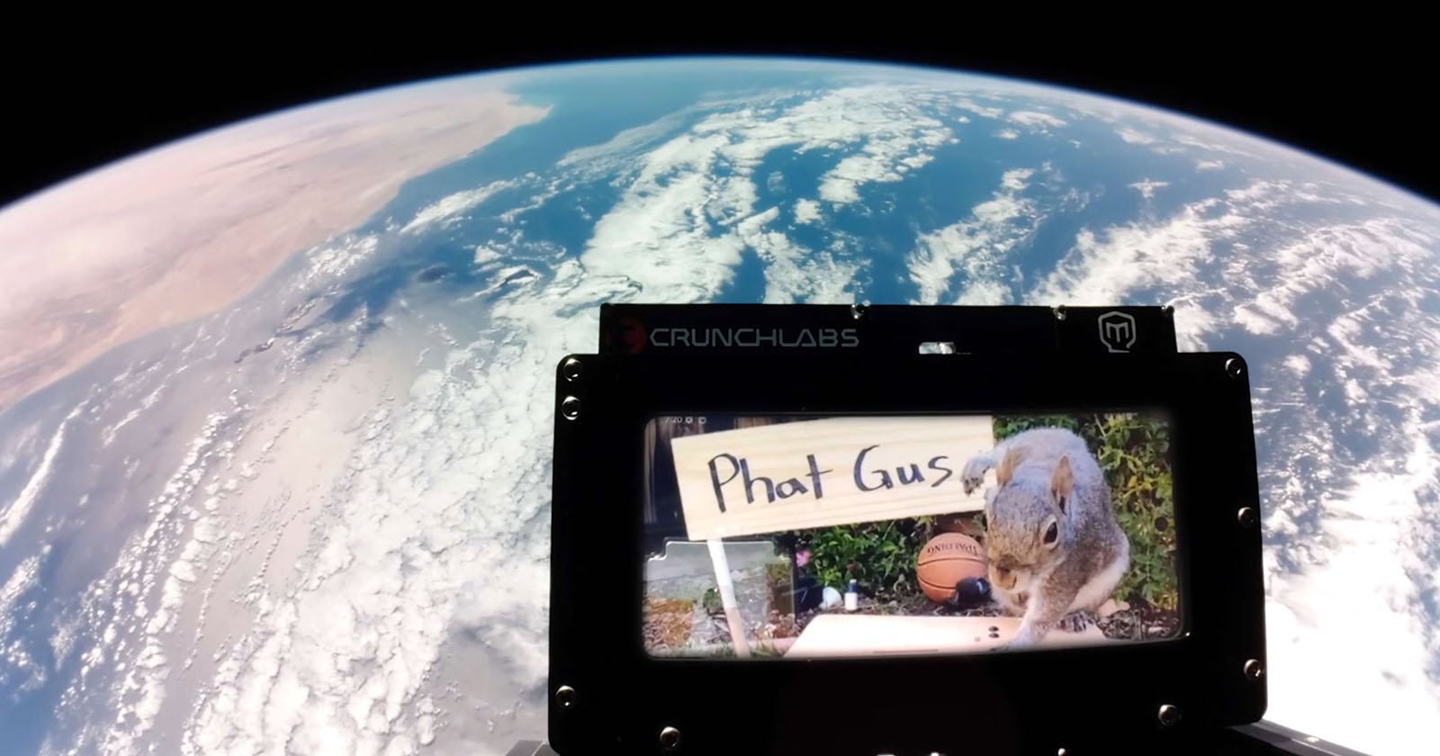 A view of Earth from space with a CrunchLabs frame in the foreground displaying an image of a squirrel next to a sign that says "Phat Gus.