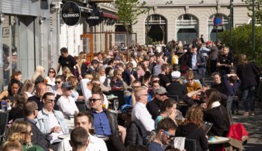 Locals and tourists enjoy the sunshine in Reykjavík's Austurvöllur square.