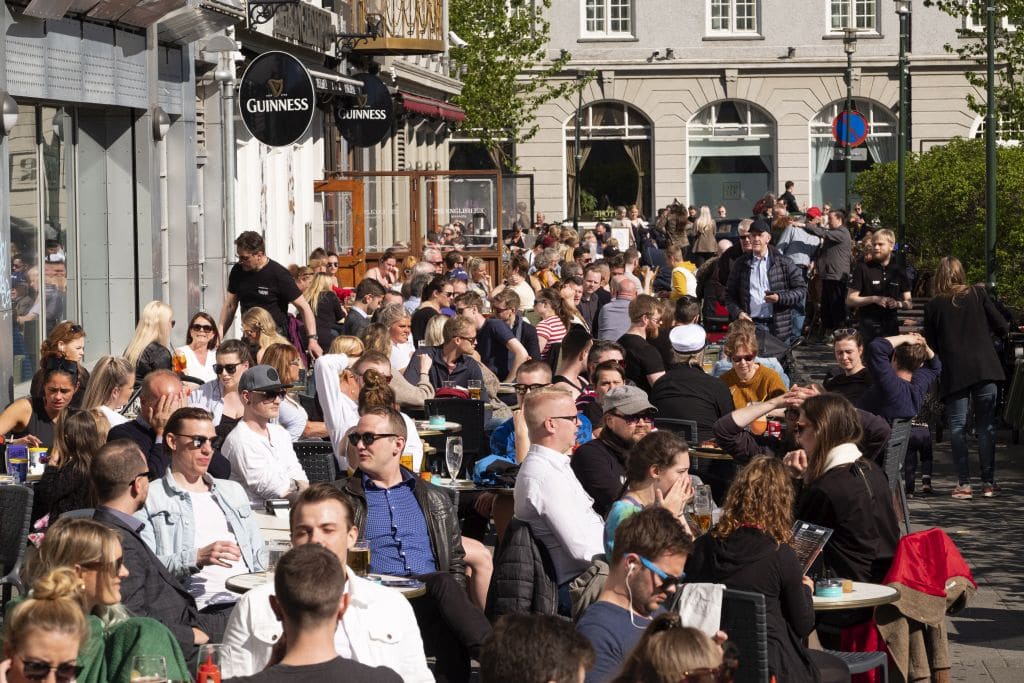 Locals and tourists enjoy the sunshine in Reykjavík's Austurvöllur square.