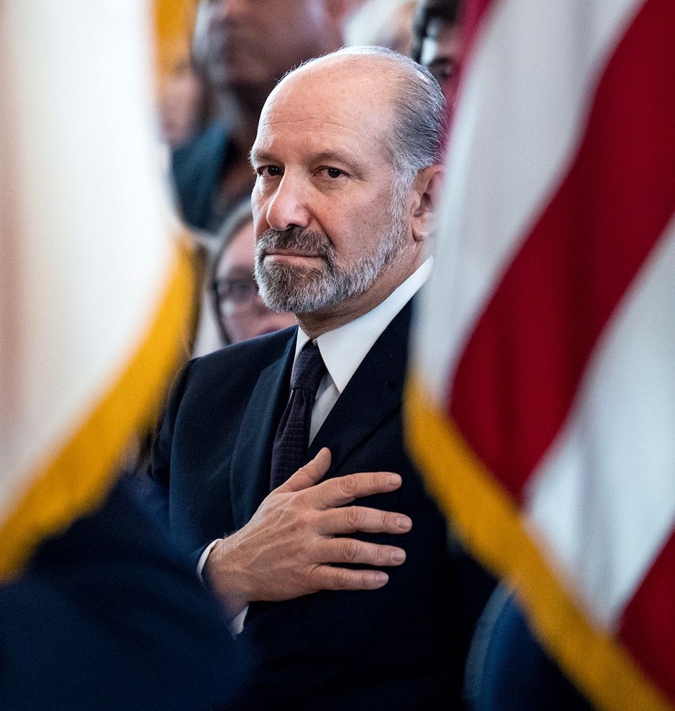 \u200bCommerce Secretary Howard Lutnick hand over heart surrounded by american flags