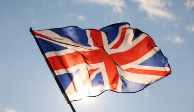 UK Great Britain flag waving in cloudy blue sky