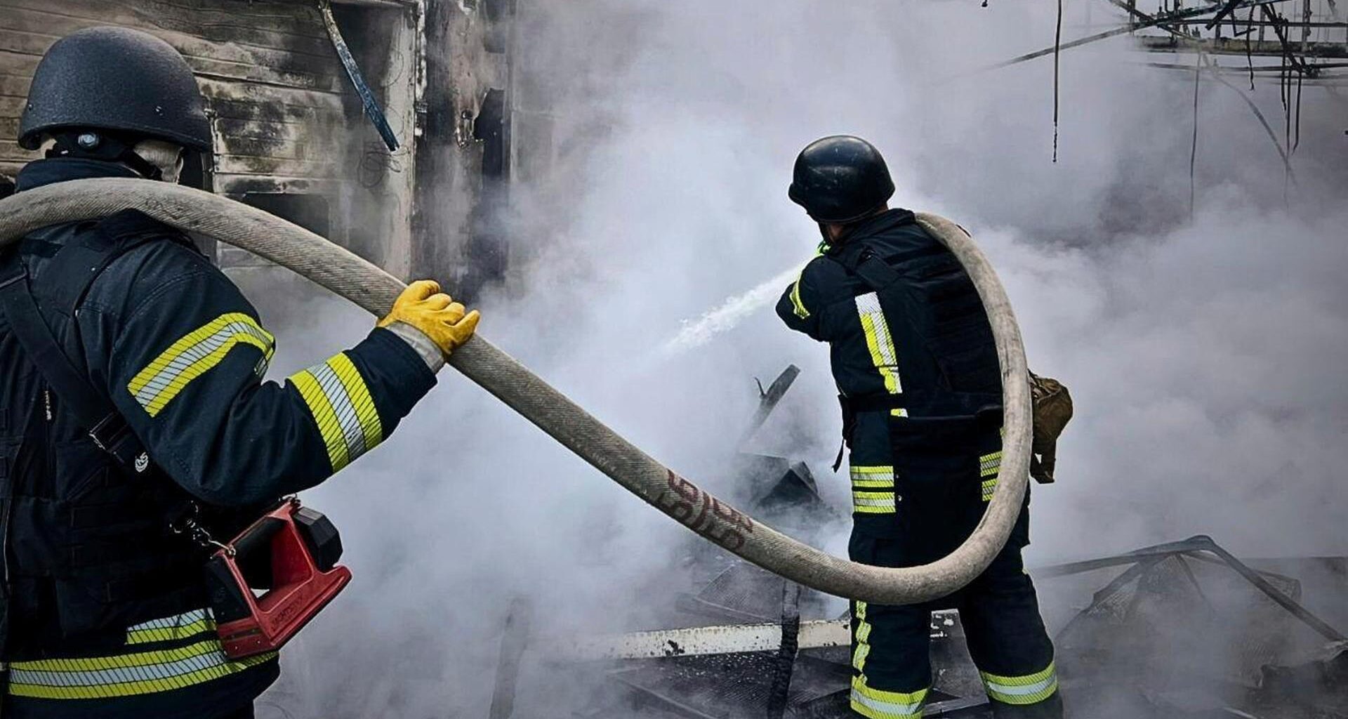 Ukrainische Feuerwehrleute löschen einen Brand in einer Halle.