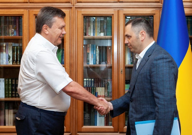 FILE PHOTO: Ukrainian President Yanukovych and Deputy Head of his Administration Portnov, shake hands in Kyiv 