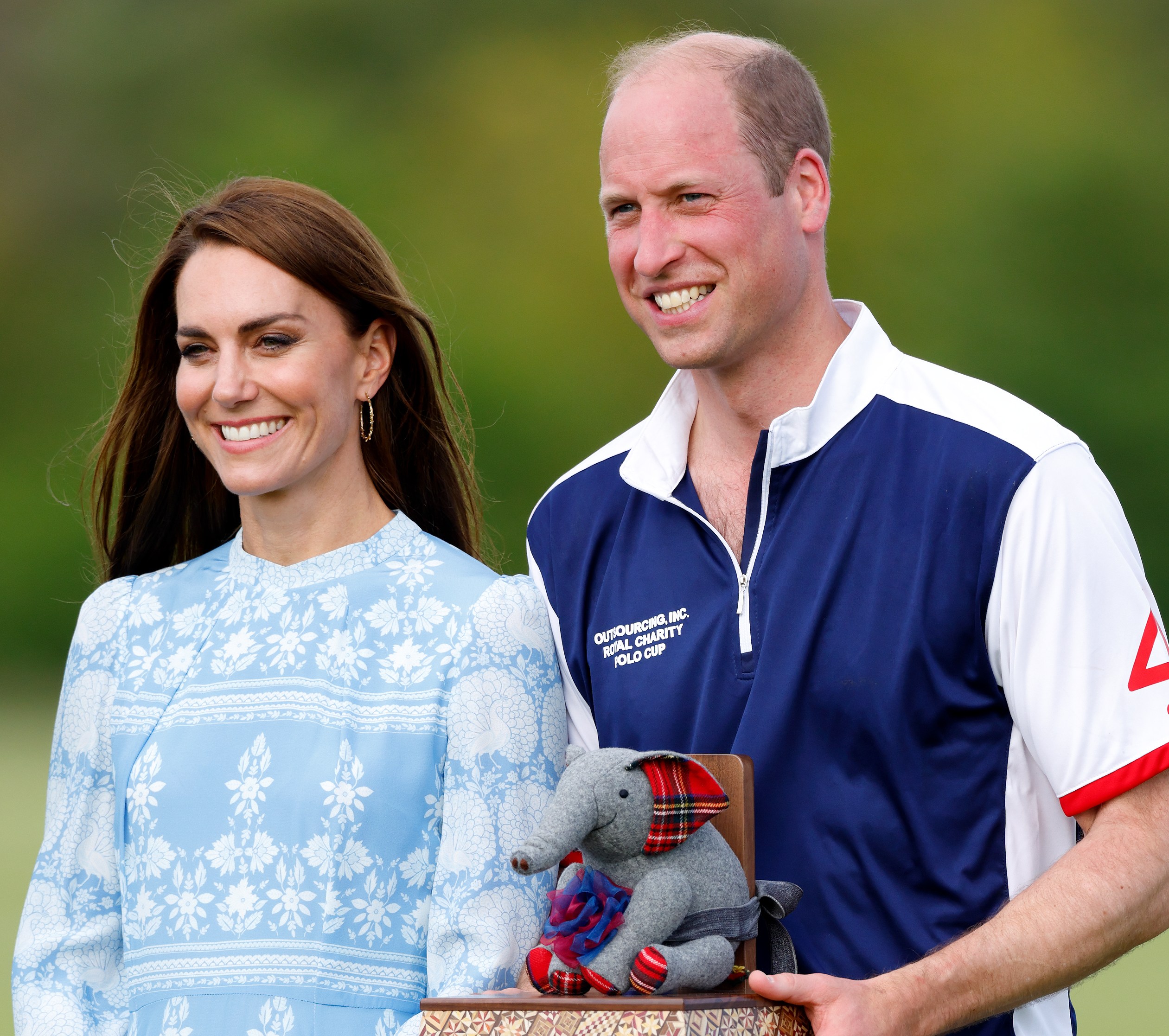 Prince William and Kate Middleton holding a polo trophy.