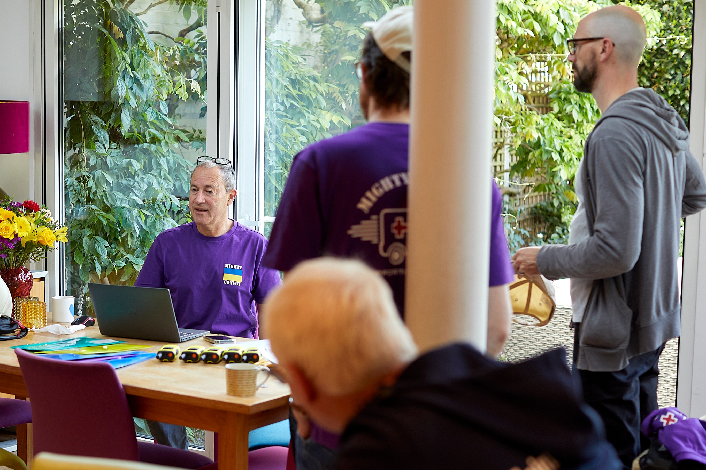 Organizers of the Mighty Convoy, a charity delivering ambulances to Ukraine, meet in a home.