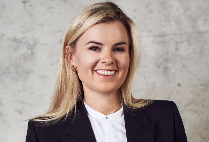 Portrait of a smiling woman in a dark blazer.