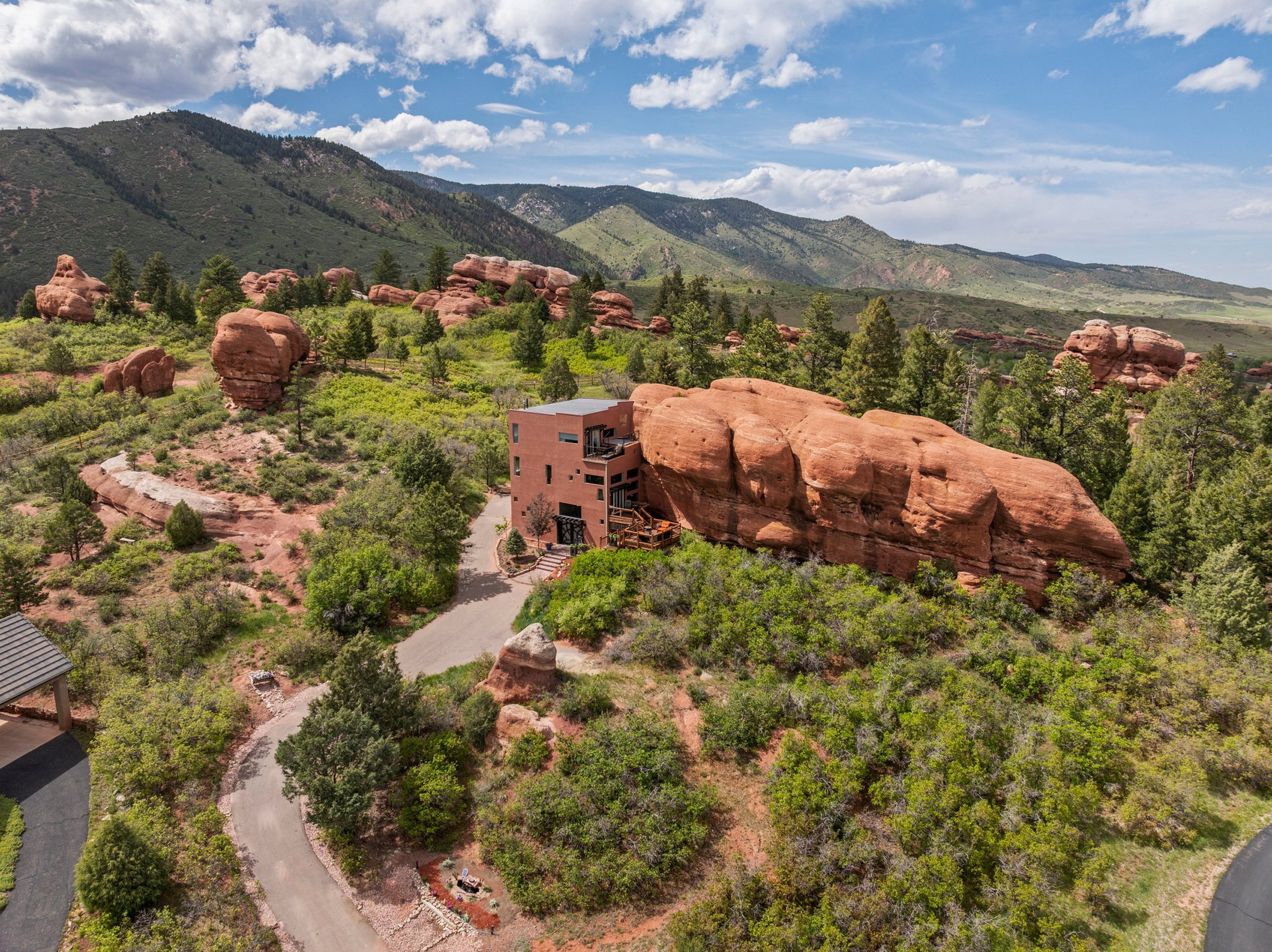 Aerial view of a house built into a red rock formation.