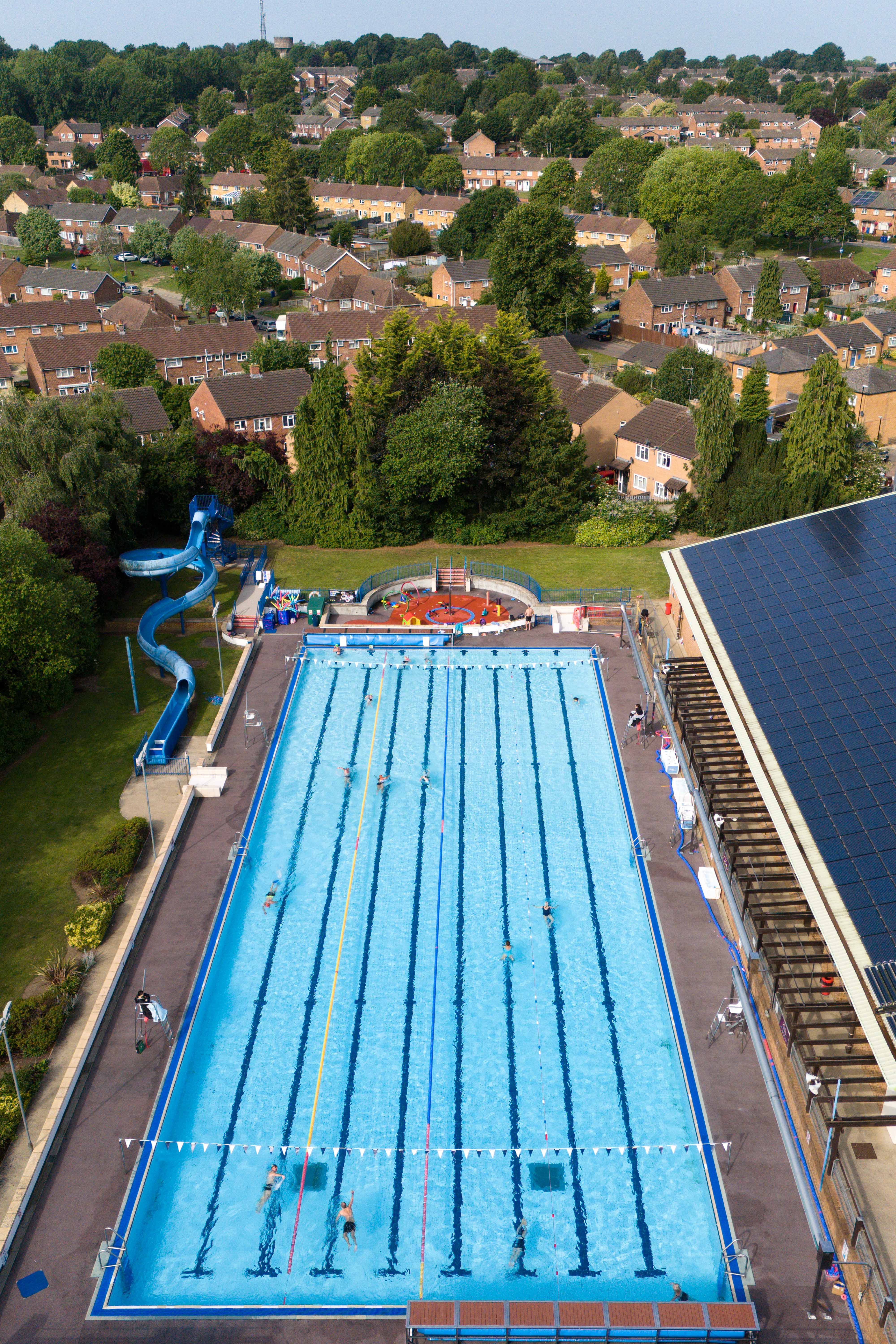 Aerial view of people swimming in an outdoor pool.
