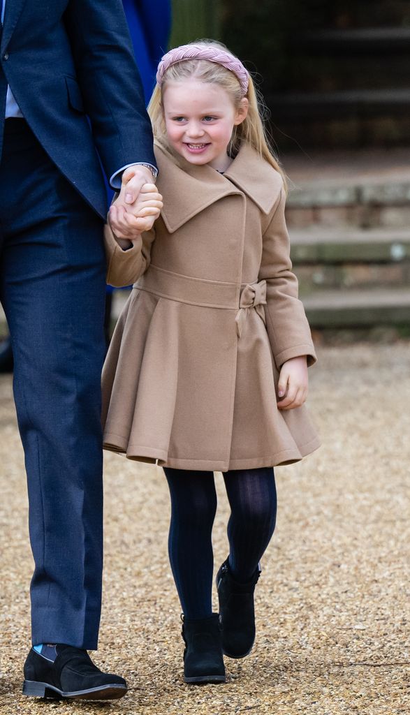 young girl walking to church in beige coat