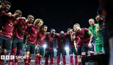 Kevin De Bruyne gives a team talk in a huddle of Belgium players