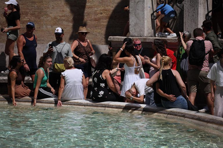 Roma, turisti trovano sollievo dal caldo estivo presso una fontana