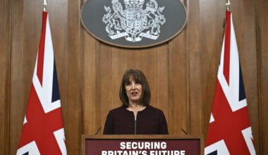Rachel Reeves standing behind a podium next to two Union Jack Flags.