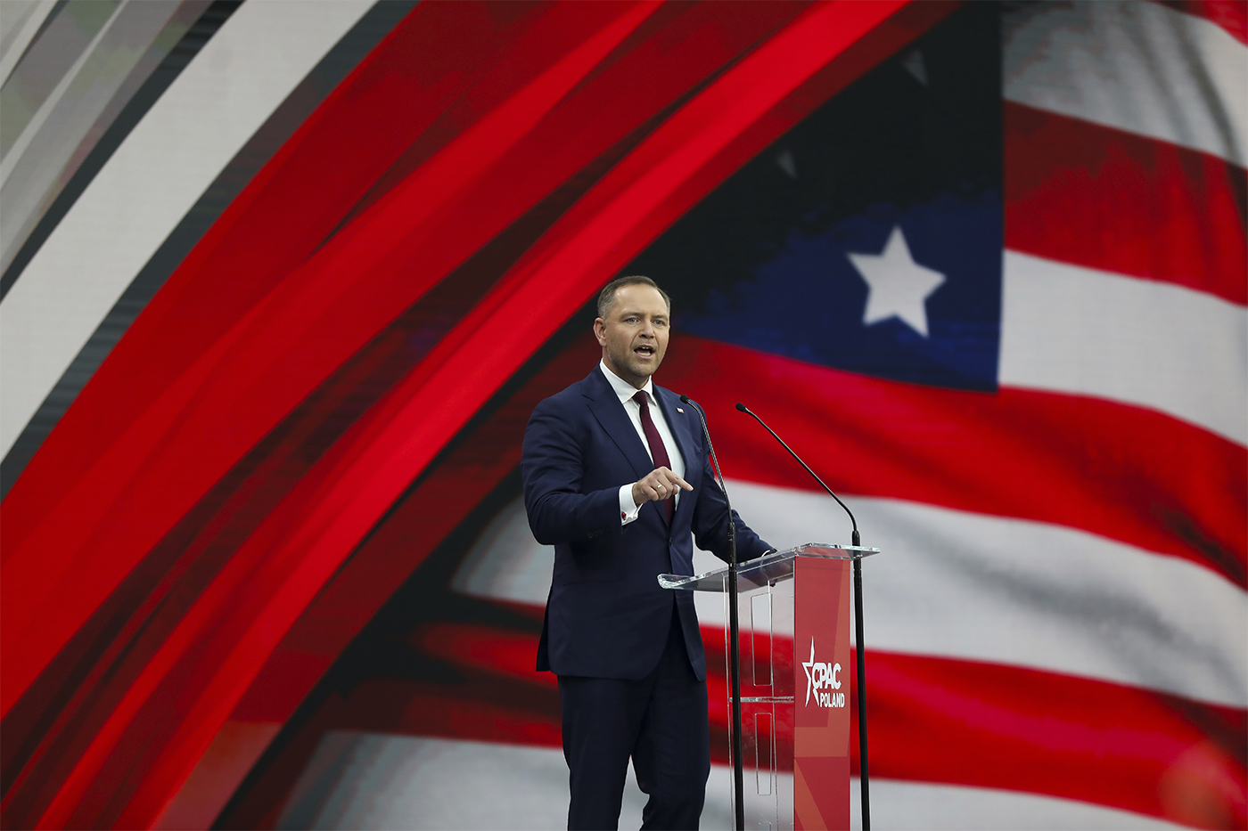Karol Nawrocki standing on stage speaking passionately.