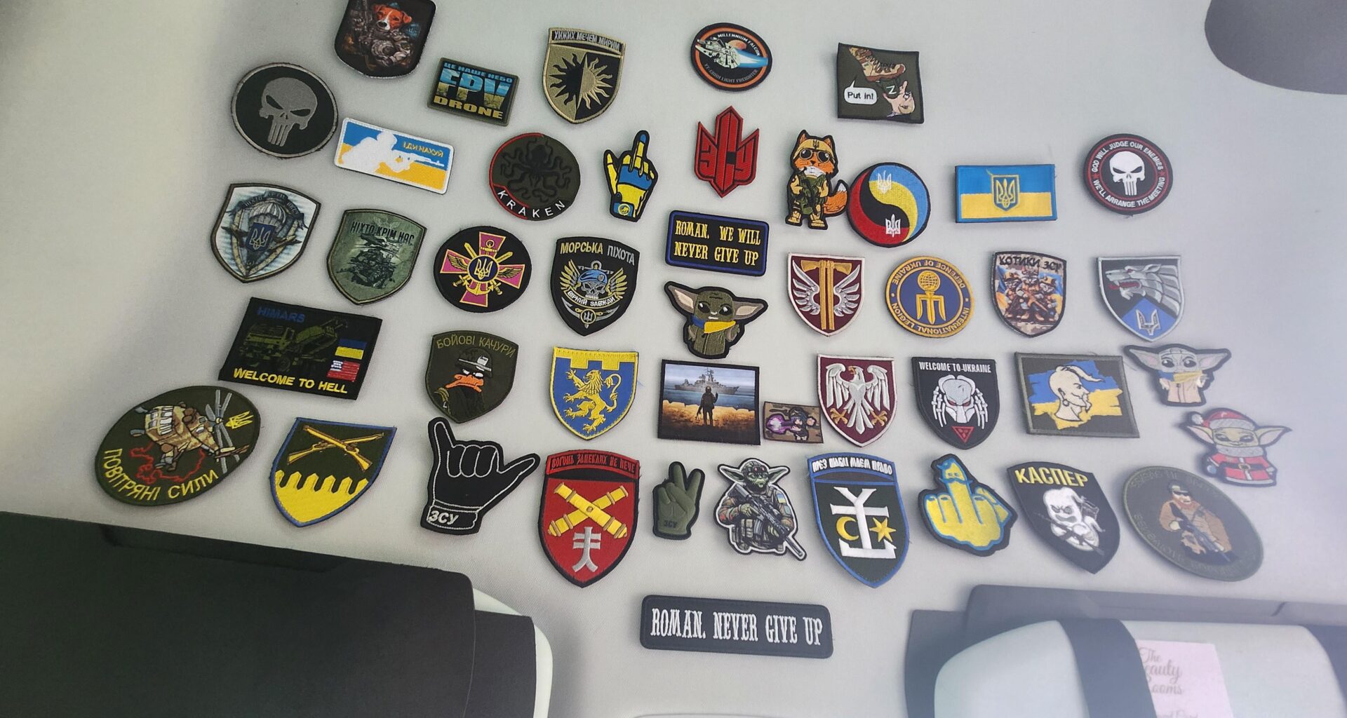 A coworker sends care packages to Ukraine. The soldiers send her their arm patches. This is her collection so far
