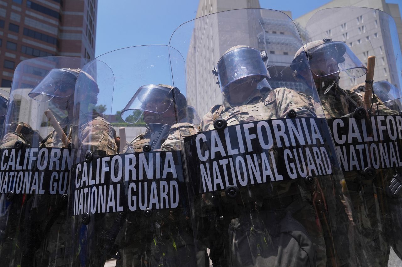Authorities stand in tear gas while trying to clear protesters at the metropolitan detention center in downtown Los Angeles, on Sunday.