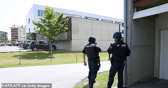 Two policemen are seen close to a school where, according to reports, several people died in a shooting, on June 10, 2025 in Graz, southeastern Austria. Several people died in a school shooting, including the attacker, Austrian broadcaster ORF quoted the interior ministry as saying. (Photo by ERWIN SCHERIAU / APA / AFP) / Austria OUT (Photo by ERWIN SCHERIAU/APA/AFP via Getty Images)