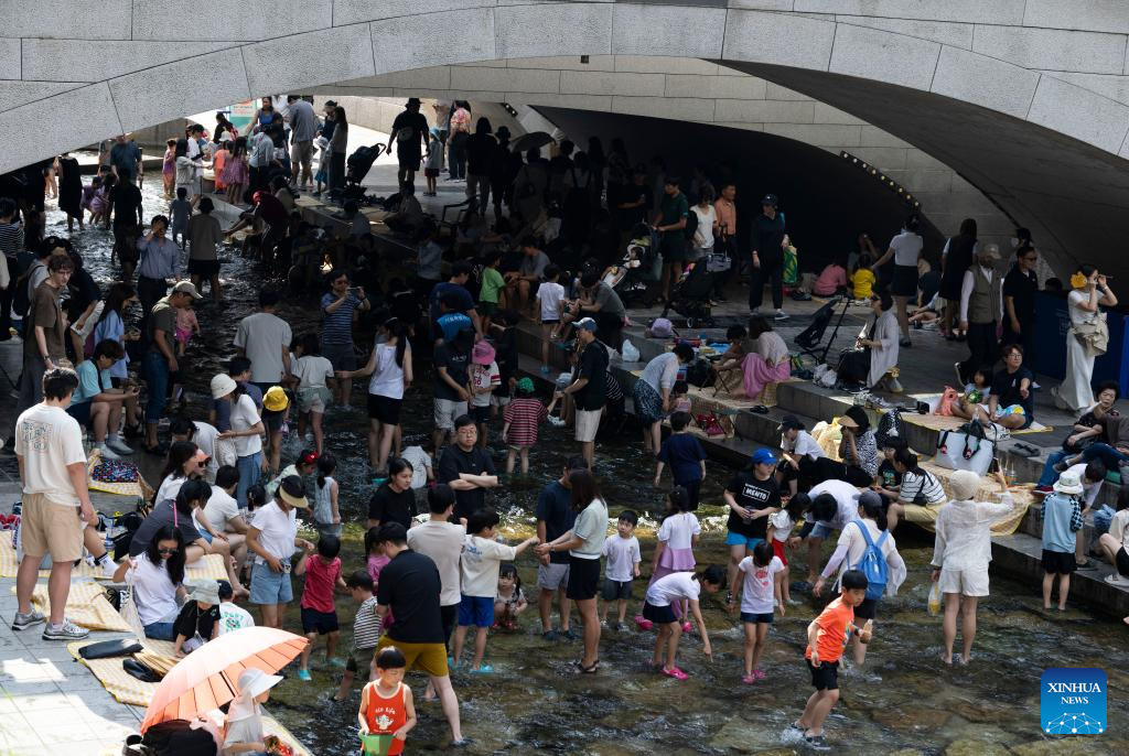 People in Seoul cool themselves off at Cheonggye stream-Xinhua