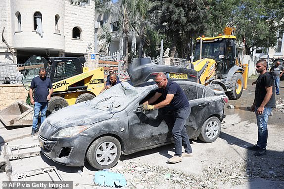Municipal workers clear the wreckage and debris in the northern Israeli town of Tamra, following an overnigh missile attack from Iran on June 15, 2025, where four people were reported killed. Israel unleashed a punishing barrage of strikes targeting the capital Tehran on June 15, after Prime Minister Benjamin Netanyahu vowed to make Iran pay "a very heavy price" for killing civilians, on the third day of fierce fighting. (Photo by AHMAD GHARABLI / AFP) (Photo by AHMAD GHARABLI/AFP via Getty Images)