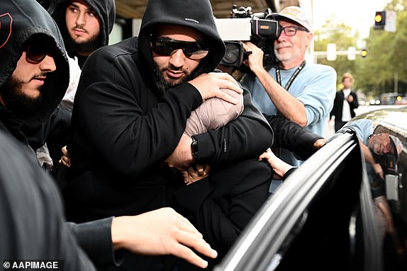 Sarah Abu Lebdeh (centre) is protected by supporters as she departs the Downing Centre Local Court, Sydney, Wednesday, March 19, 2025. Two nurses have been charged over comments made in a video chat with an Israeli influencer. (AAP Image/Bianca De Marchi) NO ARCHIVING