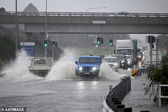 Cars make their way through floodwaters at Albion Park, Wollongong, Friday, May 23, 2025. Torrential rain continues to fall across New South Wales causing widespread flooding and resulting in the death of 4 people on the Mid North Coast. (AAP Image/Dean Lewins) NO ARCHIVING 14858951