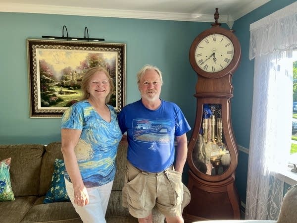 Katherine and Bill stand with the grandfather clock Bill made