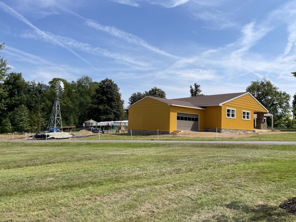 Yellow house with windmill in a park.