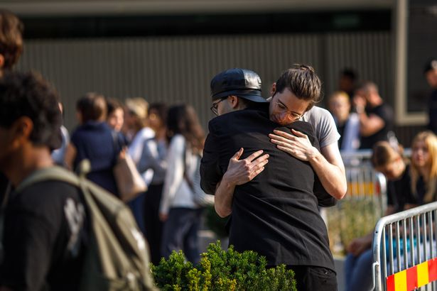 A photo of two people embracing following the shooting