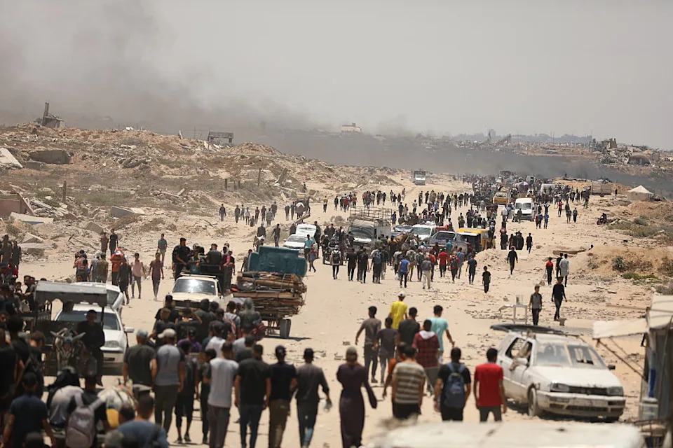Palestinians walk toward the aid distribution point in the Netzarim Corridor under the shadow of widespread destruction in Gaza on June 28, 2025.<span class="copyright">Dawoud Abo Alkas—Anadolu/Getty Images</span>