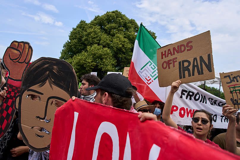A woman holds a placard during a demonstration ahead of the NATO summit in The Hague, Netherlands, Sunday, June 22, 2025.