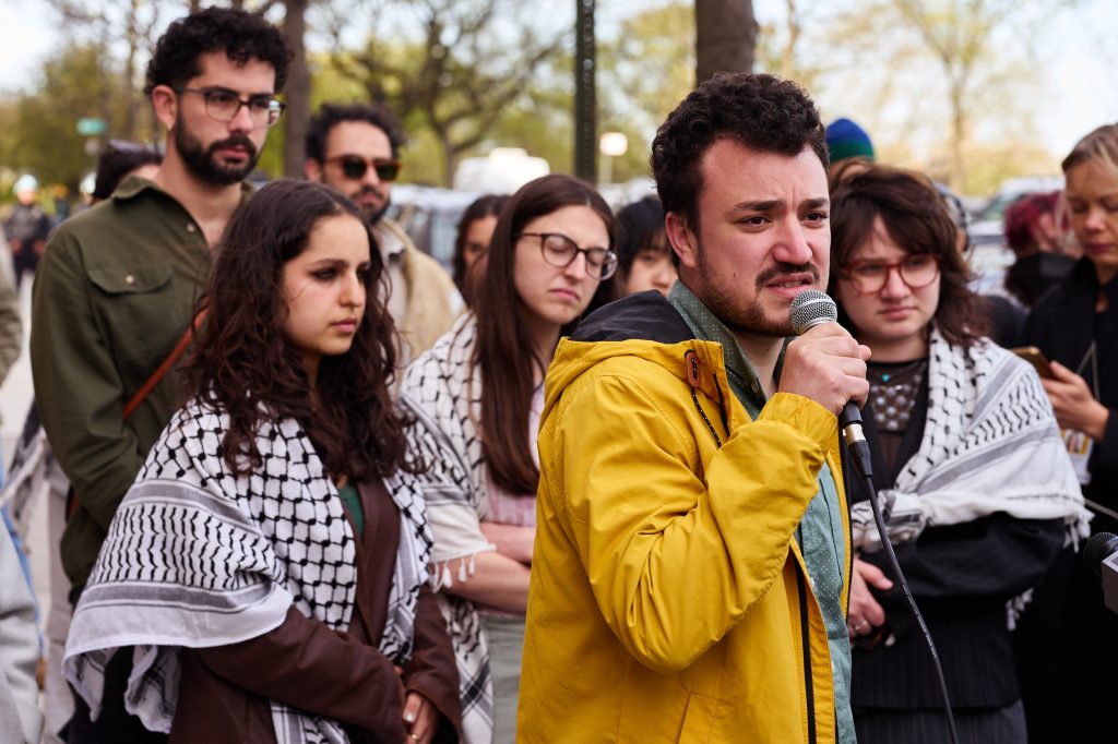 Mahmoud Khalil speaking into a microphone at a protest.