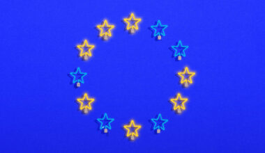 illustration of the European Union flag, with a circle of stars against a blue background. The stars alternate in color between blue and yellow, resembling neon lights
