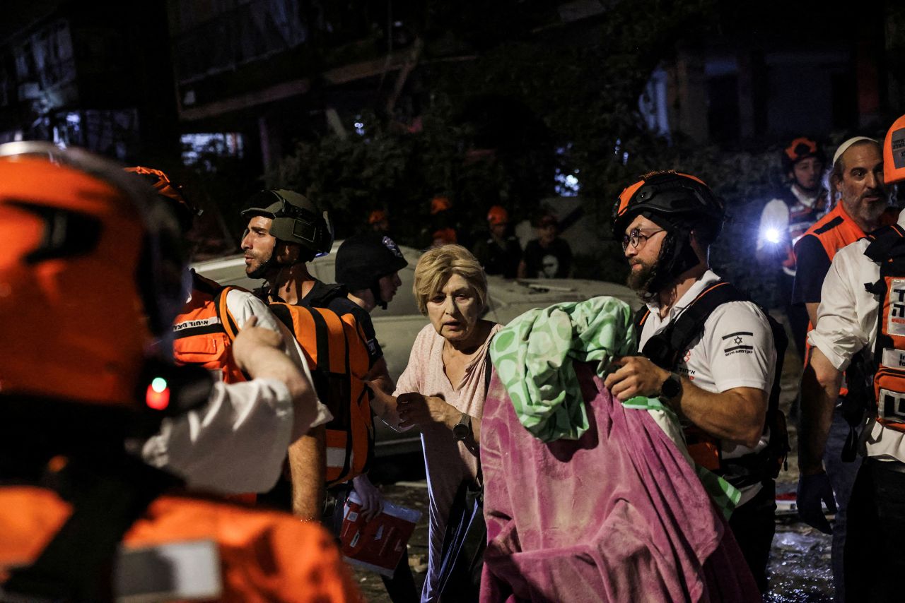 Rescue and security personnel help an injured woman in Bat Yam.