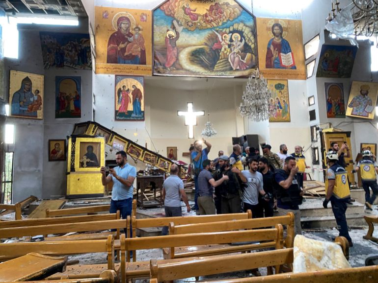 People and civil defence members inspect the damage at Damascus church after attack