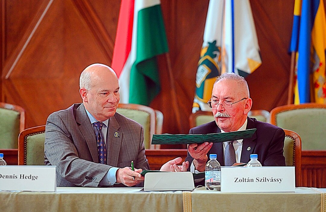 SDSU Provost and Vice President for Academic Affairs Dennis Hedge exchanges documents with University of Debrecen Rector Zoltán Szilvássy as part of an academic cooperation agreement signing last month in Hungary.