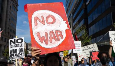 A demonstrator holding a "No War" sign protests in the United States.