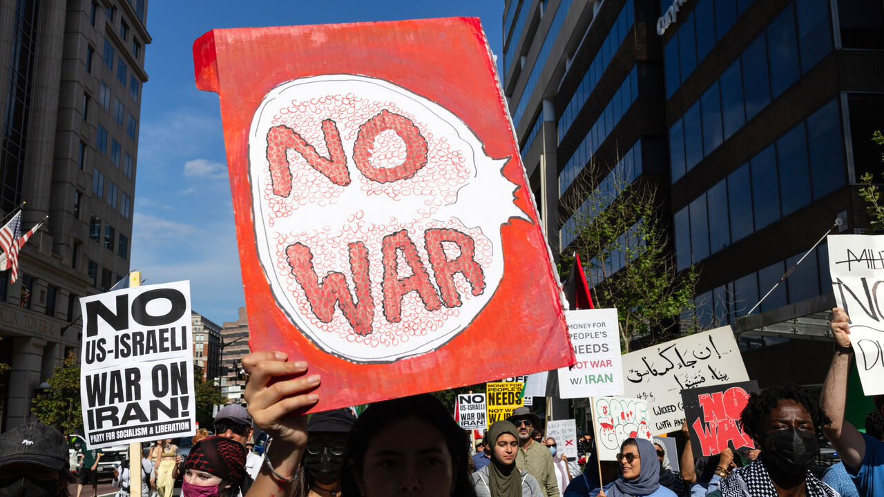 A demonstrator holding a "No War" sign protests in the United States.