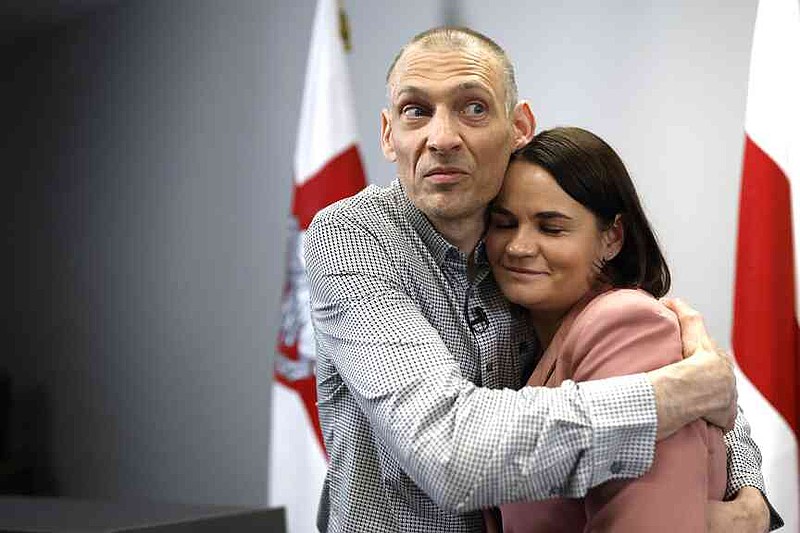 Syarhei Tsikhanouski, left, Belarusian opposition activist released from a Belarusian prison, embraces his wife, Belarusian opposition leader Sviatlana Tsikhanouskaya, after a news conference in Vilnius, Lithuania, Sunday, June 22, 2025. (AP Photo/Mindaugas Kulbis)